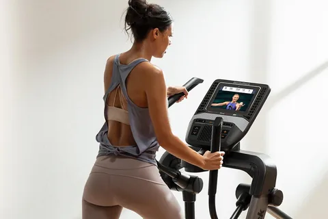 Jeune femme de dos sur un vélo elliptique