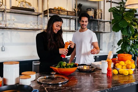 Couple en pleine préparation d'une salade de légumes