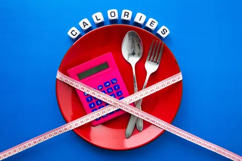 Calories Assiette rouge avec une calculatrice et un mètre