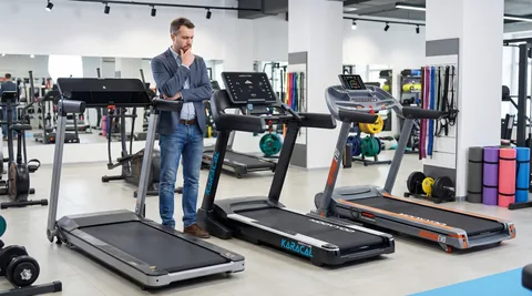 Homme en t-shirt, se tenant la tête comme s'il hésitait, avec plusieurs tapis de course en vignette