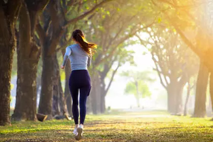 Jeune femme faisant de la course à pied dans un bois