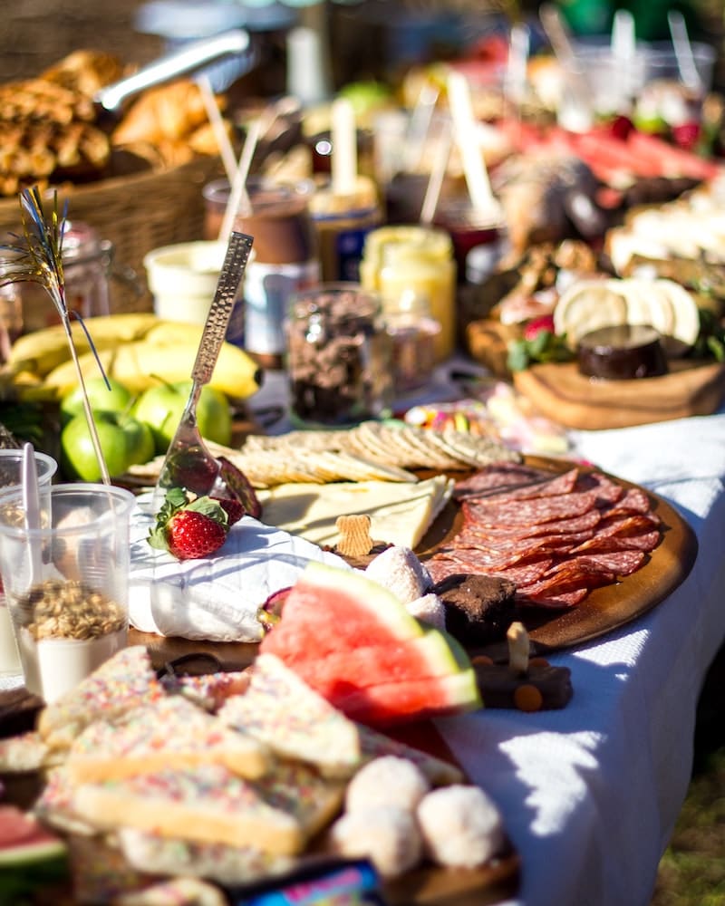 Buffet de nourriture avec du jambons, du fromages, des fruits, etc.