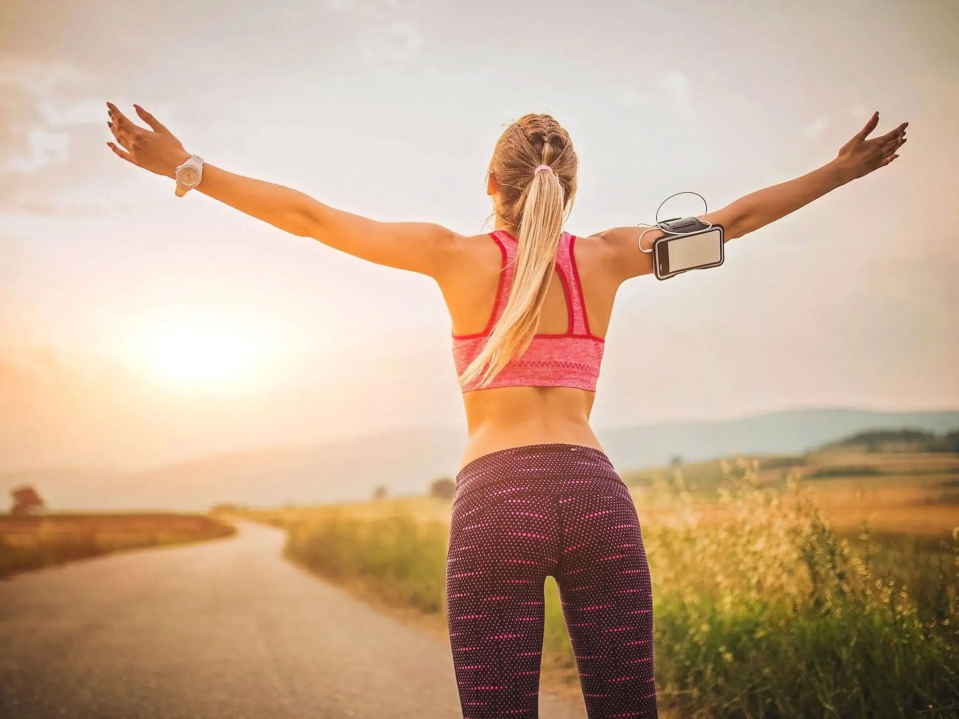 Femme de dos les bras écartés après sport