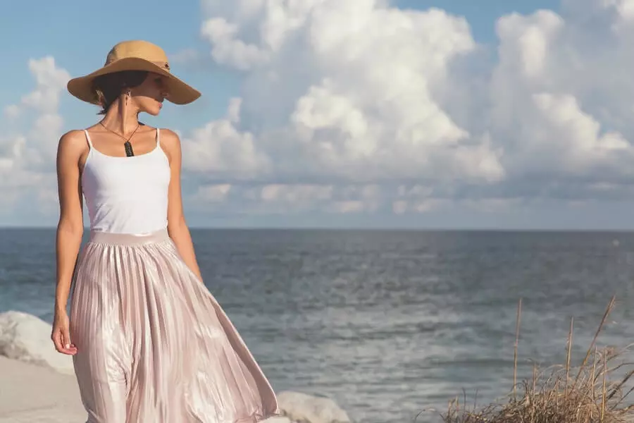 Jeune femme face à la mer avec un chapeau