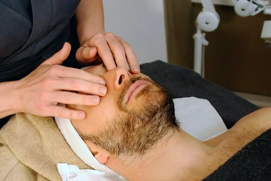 Massage du visage en institut réalisé sur un homme