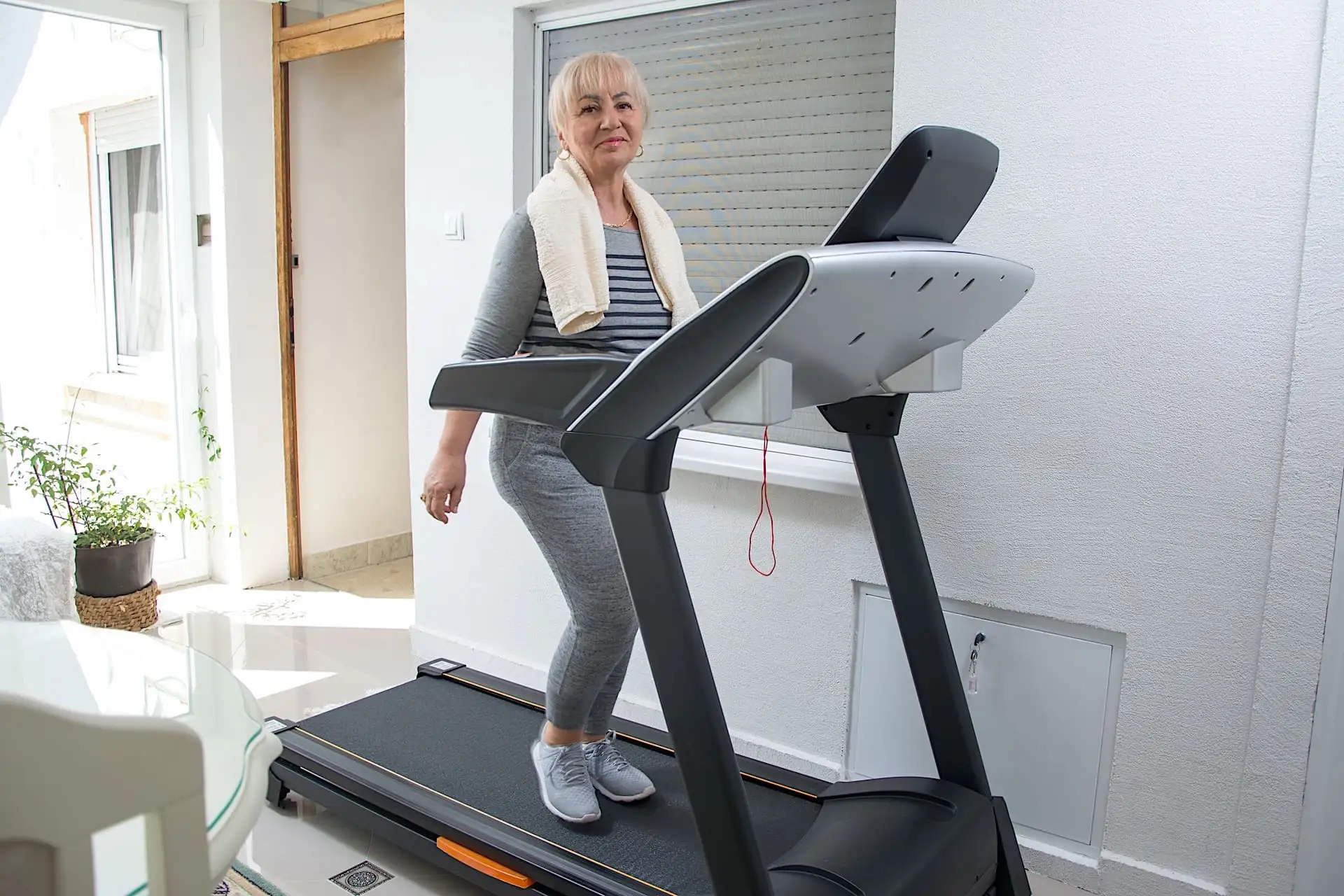 Pratique du tapis de course Femme âgée sur un tapis de course dans sa maison