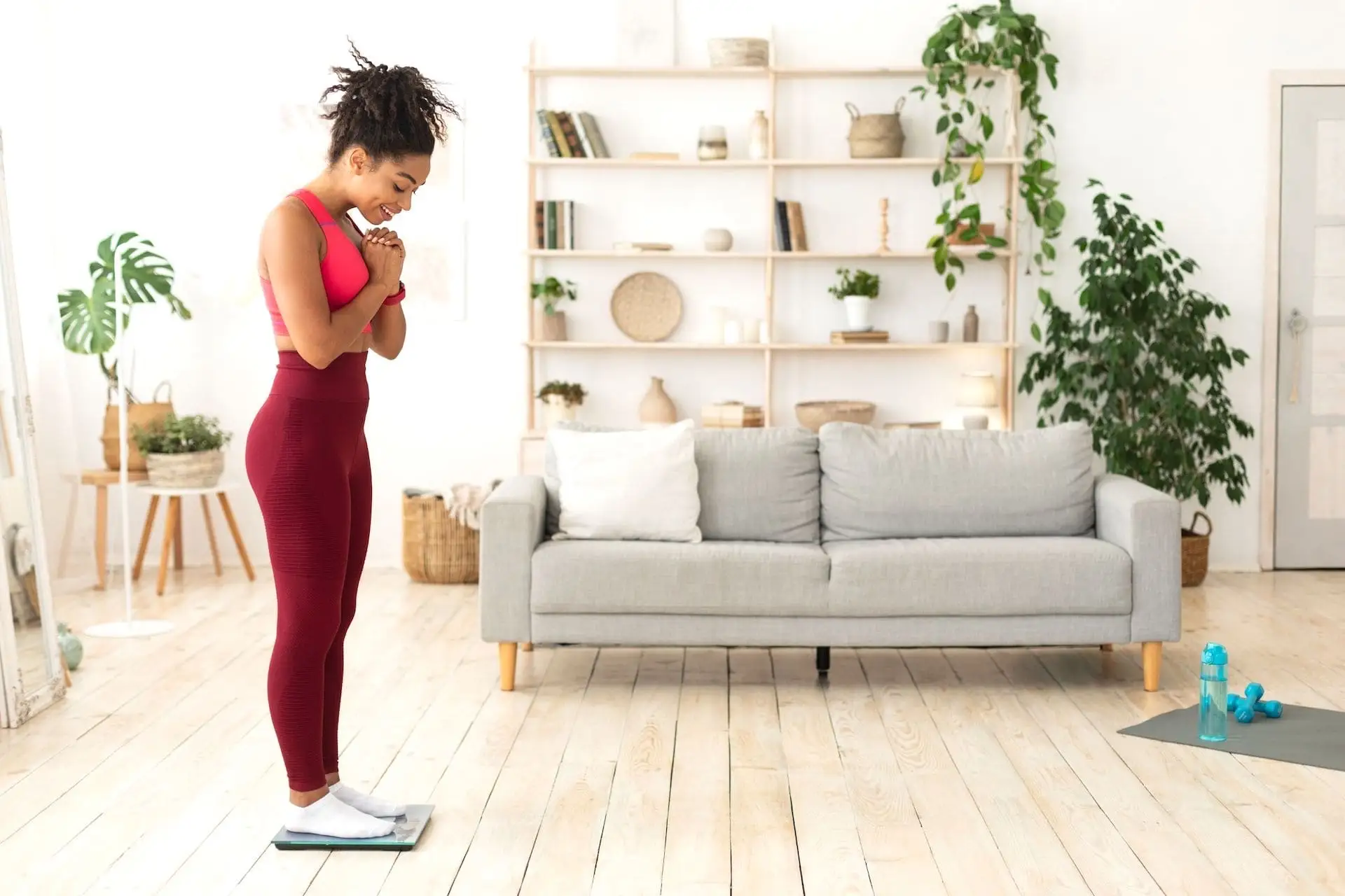 Jeune femme sur une balance contente de sa perte de poids