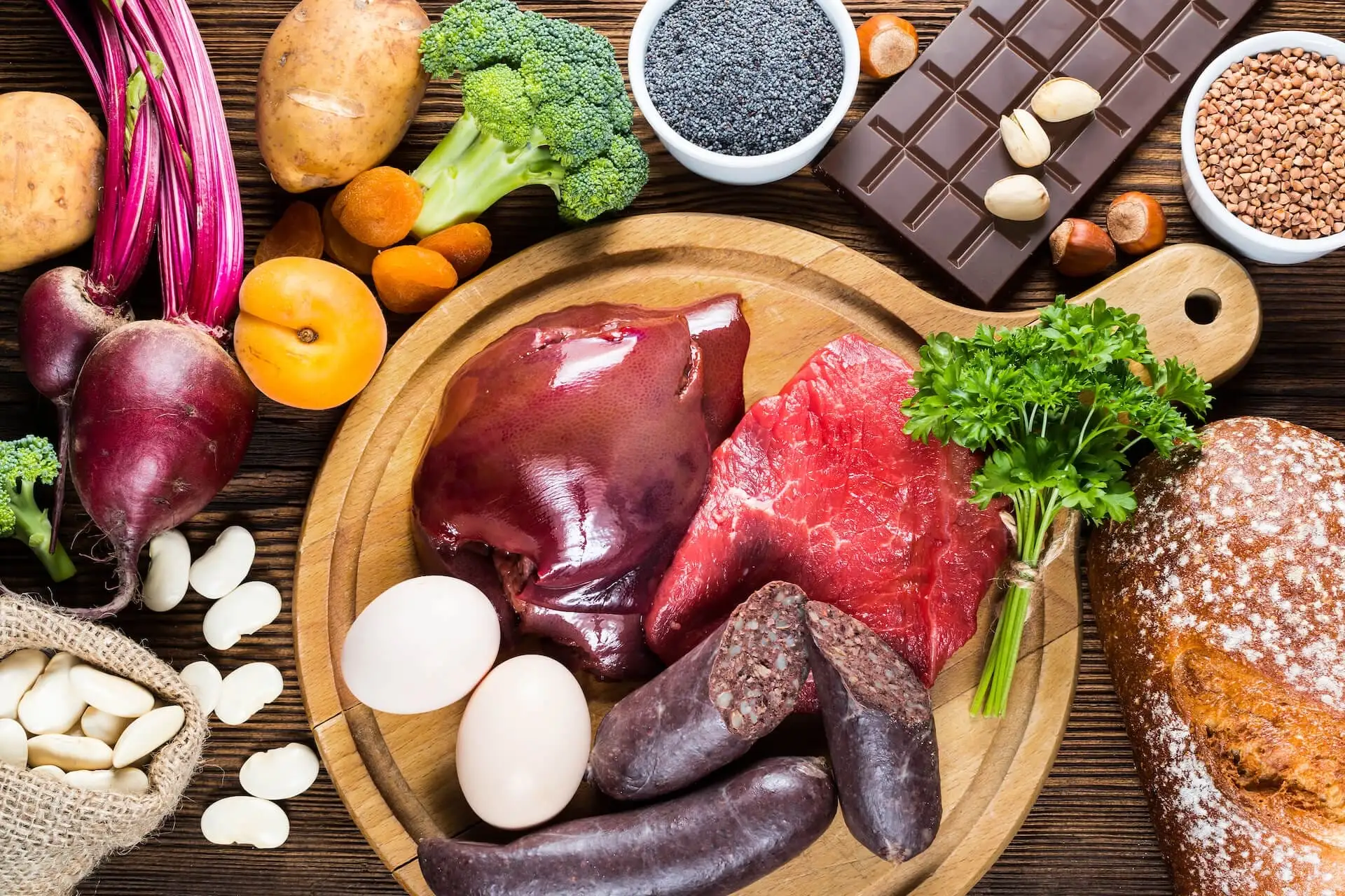 Aliments riches en fer Table en bois avec des aliments riches en fer : Foie, steak, rognon, abricot