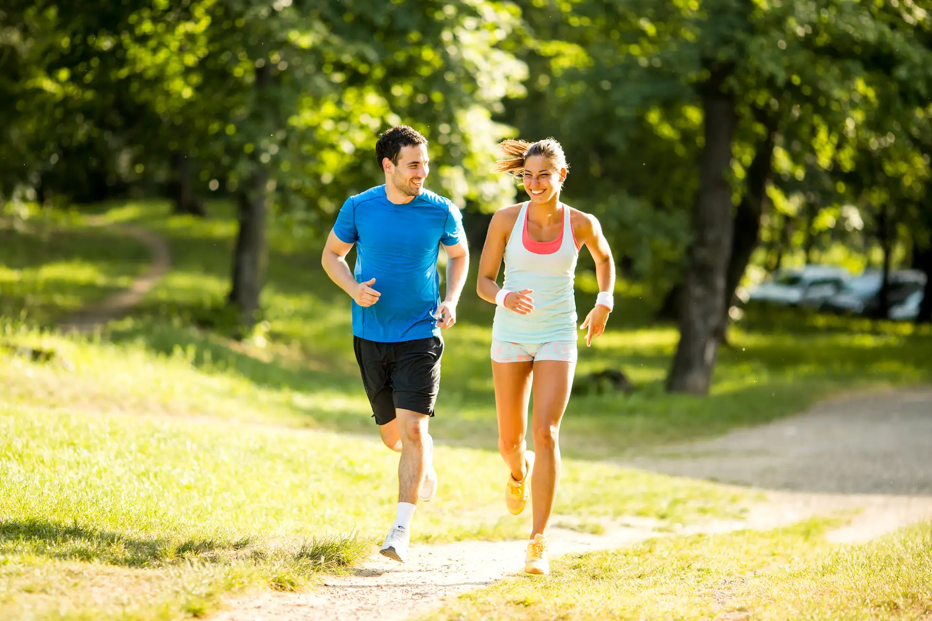 Un couple de sportifs en train de courir dans un sous-bois