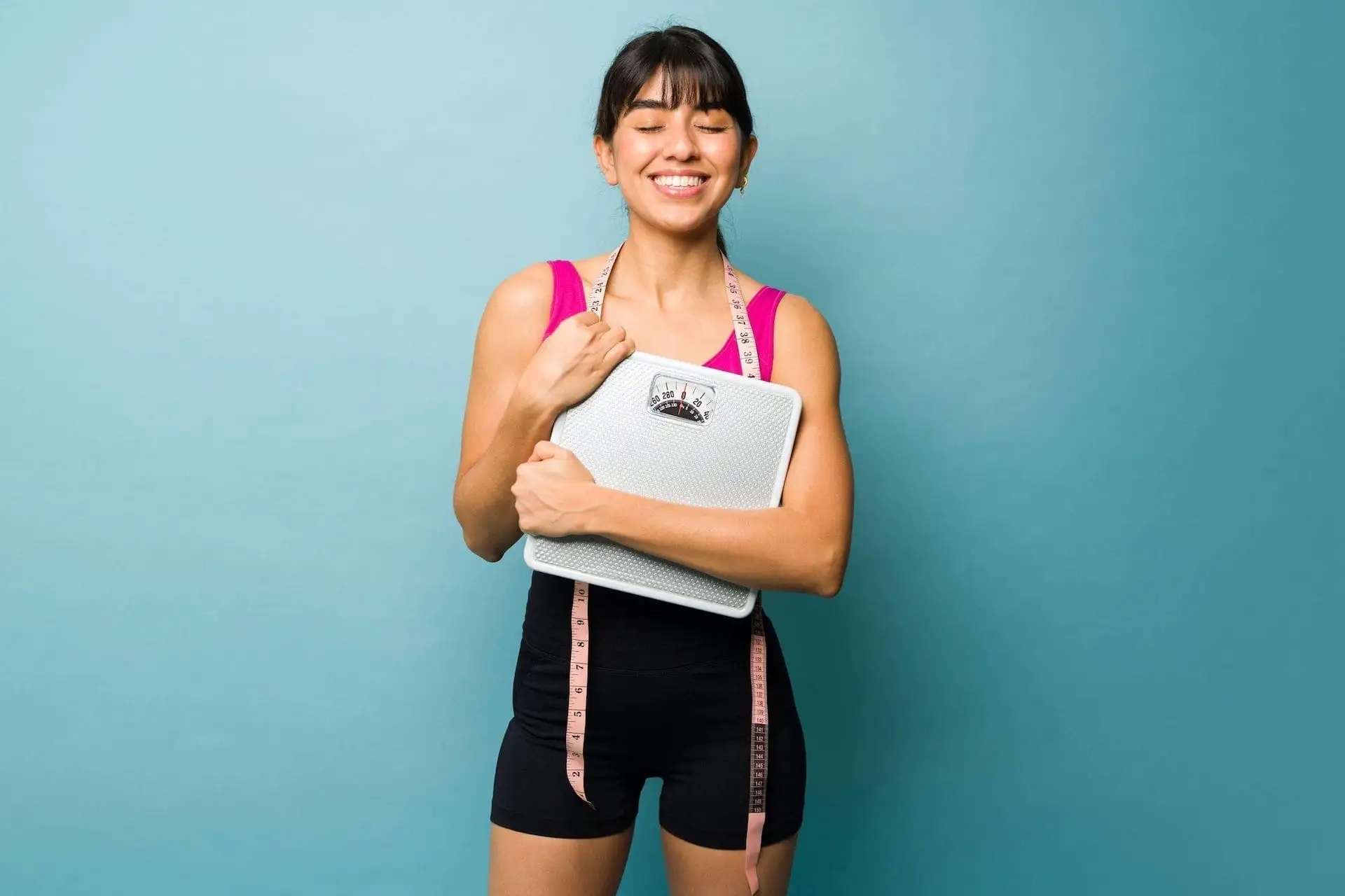 Jeune femme avec une balance et un mètre de tour de taille